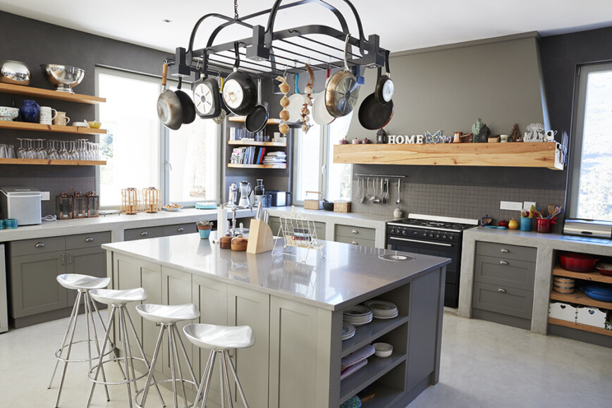 Grey kitchen with island and overhanging pots and pans