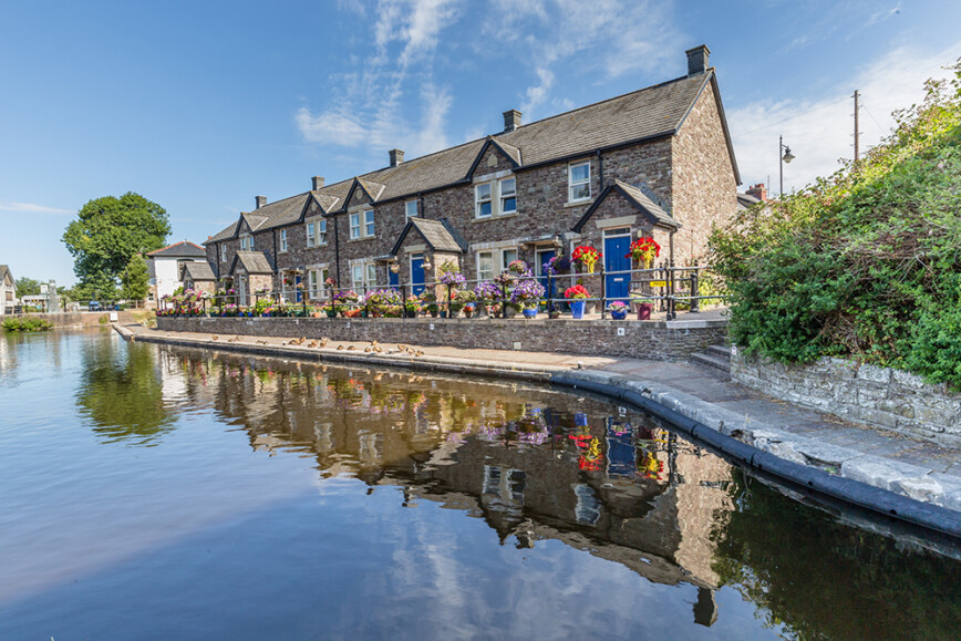 Cottages reflecting in the water of Brecon Canal basin in Brecon town, Brecon Beacons National Park, Wales, UK