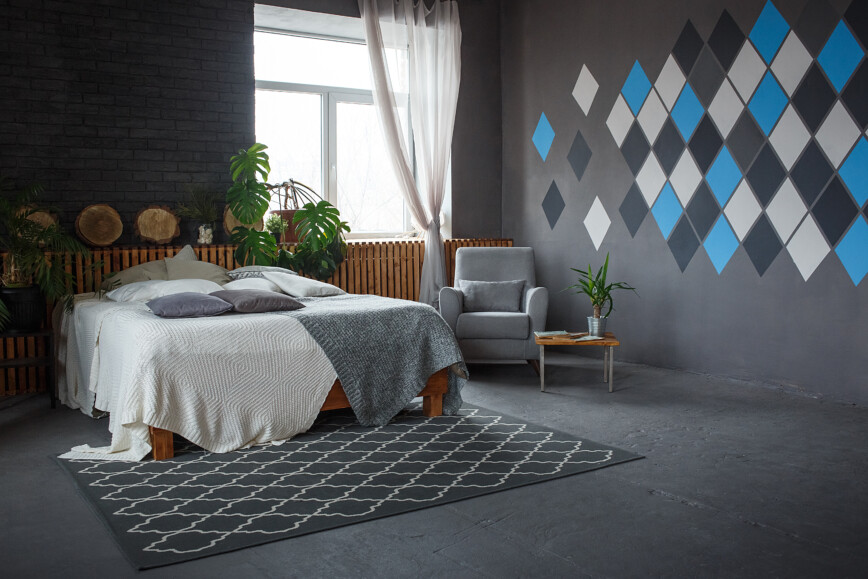 Stylish bedroom in grey with geometric design painted on walls