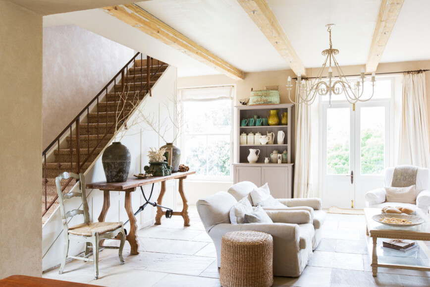 Country cottage decorated in white with tiled floor and chandelier.