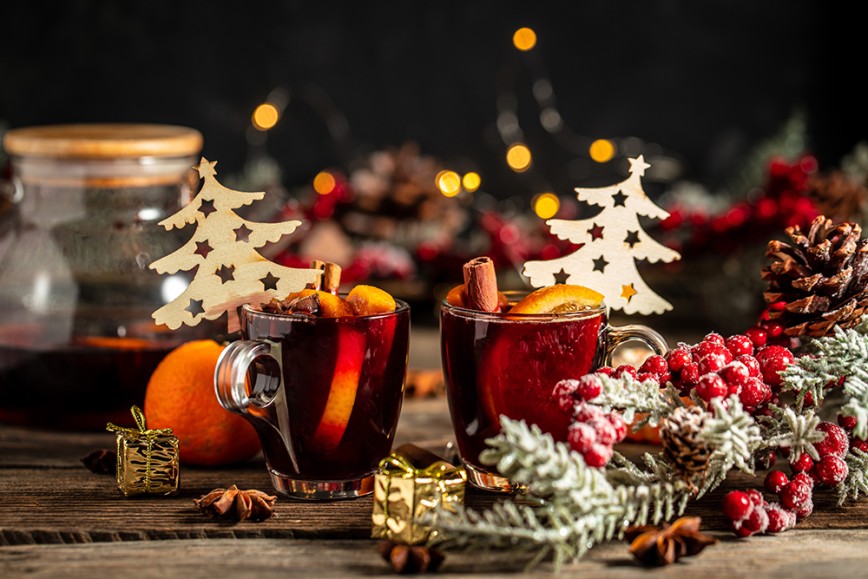 Mulled wine in glass mugs surrounded by Christmas decorations