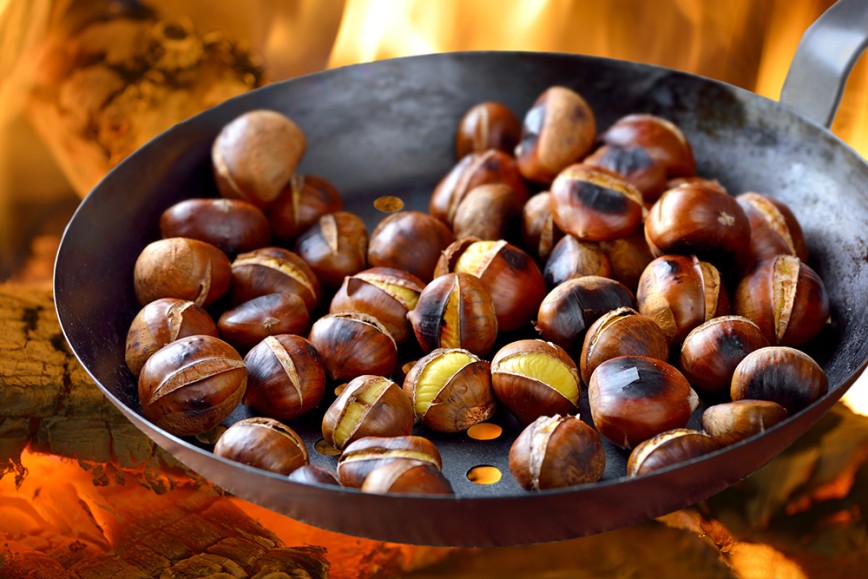 Roasted Chestnuts in a pan over flames