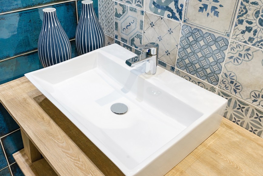 White sink next to Moroccan blue and white tiles and blue subway tiles